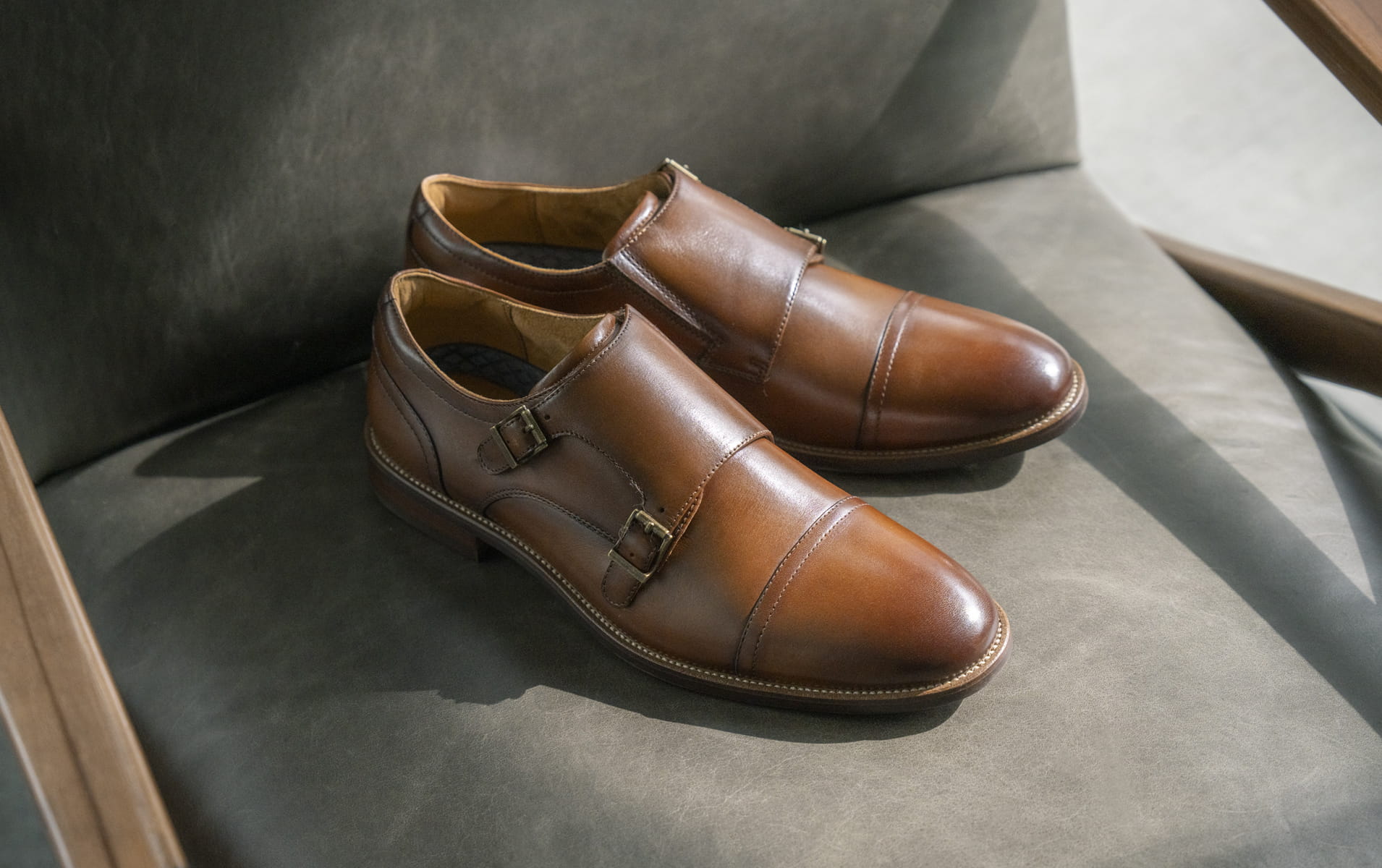 Florsheim dress featuring the Rucci Cap Toe Double Monk in cognac on a grey chair.