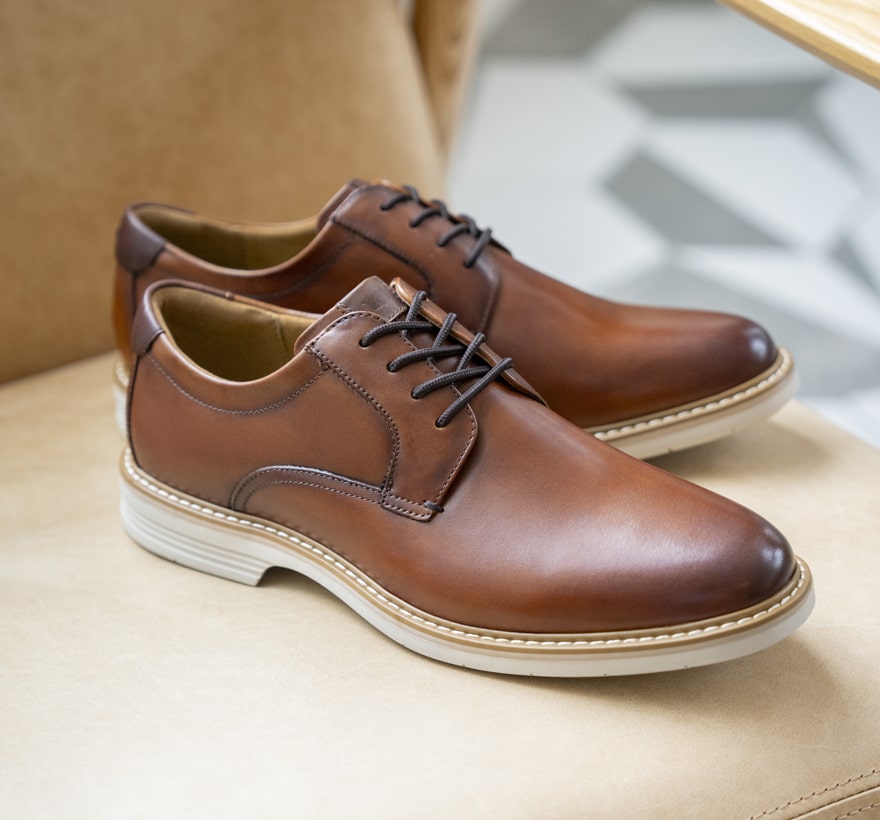 Image features the Norwalk plain toe oxford in cognac on a chair.