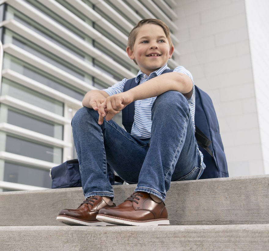 Image features the Vibe Jr. in cognac on a child sitting on stairs.